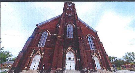 St. Anthony church, a tall red-brick Gothic façade with a central clock tower / La iglesia de St. Anthony, alta fachada gótica de ladrillo rojo con torre del reloj central