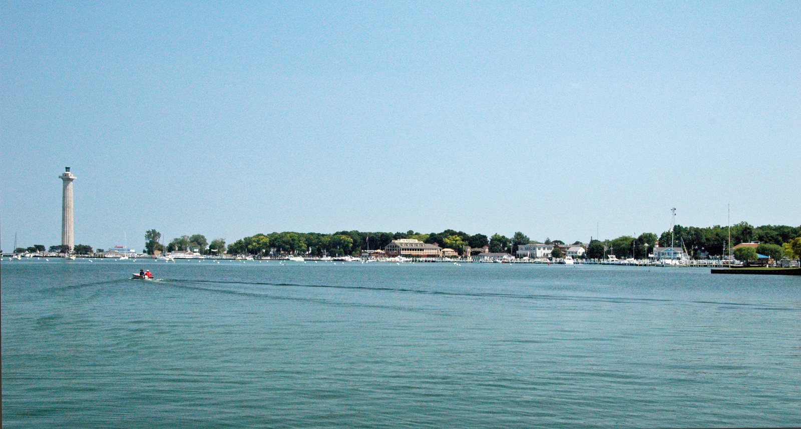 The Doric column of Perry’s Victory and International Peace Memorial rising above the harbor at Put-in-Bay on South Bass Island, seen from the water / La columna dórica del Monumento a la Victoria de Perry y a la Paz Internacional se alza sobre el puerto de Put-in-Bay, en South Bass Island, vista desde el agua