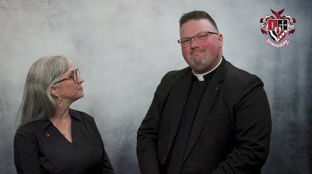 Principal Malinda Siers and the Rev. Scott Woods standing before a gray backdrop with the school crest, in the video announcing the closing / La directora Malinda Siers y el reverendo Scott Woods de pie ante un fondo gris con el escudo de la escuela, en el video que anunció el cierre