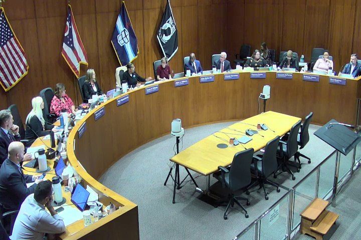 Toledo City Council members seated at the curved dais in council chambers during the Oct. 20 meeting, with the empty witness table in the foreground. / Miembros del Concejo Municipal de Toledo sentados en el estrado curvo de la sala del concejo durante la reunión del 20 de octubre, con la mesa de testigos vacía en primer plano.